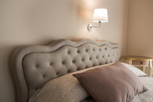 a bed with a headboard with a pillow and a lamp at Palazzo Bove in Galatone