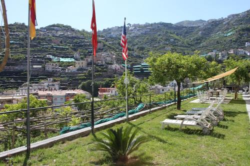 a park with benches and flags on a hill at Eden Holiday in Minori