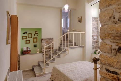 a room with a staircase and a stone wall at Antouanetta Apartments in Ermoupoli