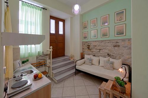 a living room with a couch and a stone wall at Antouanetta Apartments in Ermoupoli