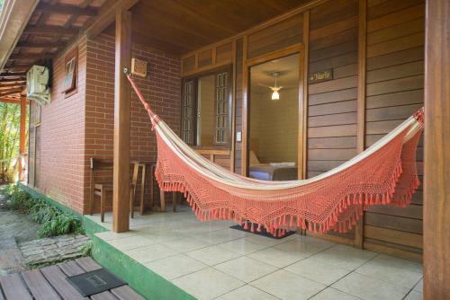a hammock hanging on the side of a house at Pousada Treze Luas in Ilha do Mel