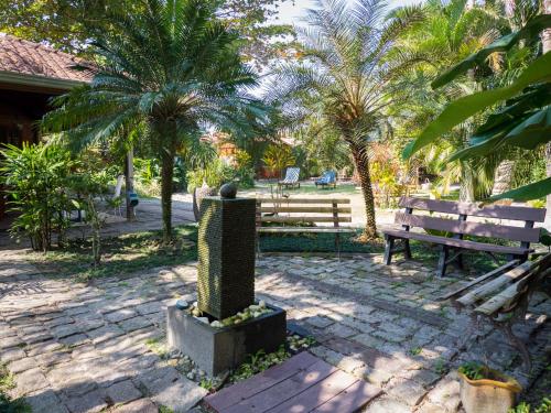 a park with a bench and palm trees in the background at Pousada Treze Luas in Ilha do Mel