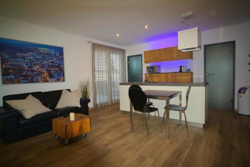 a kitchen and living room with a couch and a table at FeWo Dansenberg in Kaiserslautern