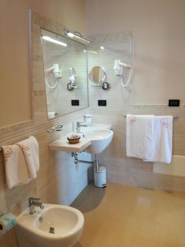 a white bathroom with a sink and a mirror at Hotel Residence Piccolo in Parghelia