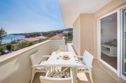 a balcony with a table and chairs and a view of the ocean at Apartments Alba in Slatine