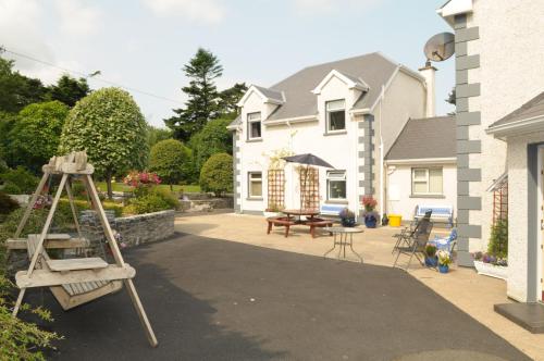 a patio with a wooden ladder and a table and chairs at Killererin House B&B in Letterkenny