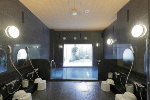 a bathroom with four toilets and a window at Hotel Route-Inn Sendaiizumi Inter in Sendai