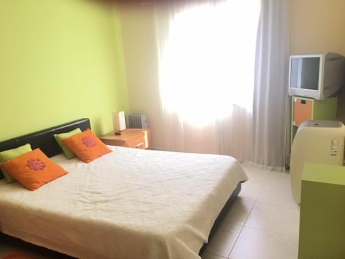 アルマカオ・デ・ペラにあるCoralのベッドルーム1室(オレンジ色の枕とテレビ付)