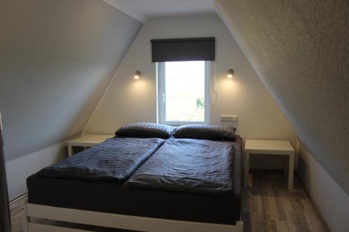 a small bedroom with a bed with a window at Ferienhaus Sonneck in Klockenhagen