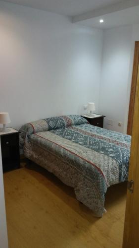 a bedroom with a bed and two night stands at Apartamento con balcón in Viveiro