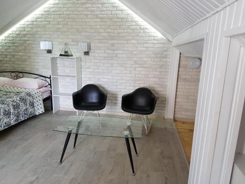 two black chairs sitting on a glass table in a bedroom at Apartments like hotel in Chernivtsi