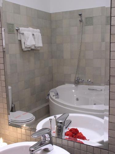 a bathroom with a tub and a sink and a toilet at Allotino Pension in Nafplio