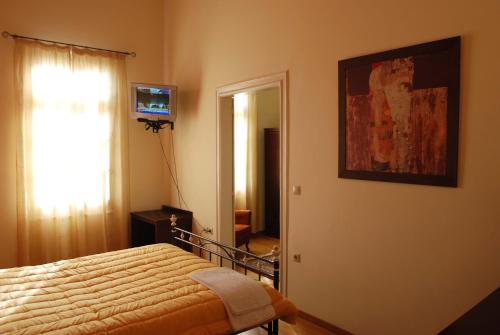 a bedroom with a bed and a picture on the wall at Allotino Pension in Nafplio