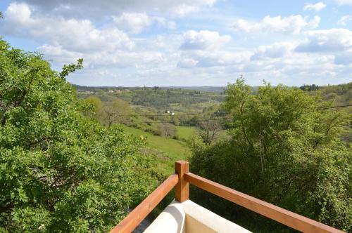 a view from the balcony of a house with trees at Aux Volets Bleus Chez Mark & Sylvie in Rouffignac Saint-Cernin