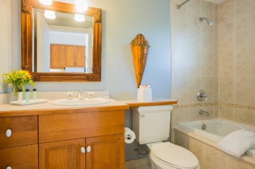 a bathroom with a sink and a toilet and a mirror at Royal West Indies in Grace Bay