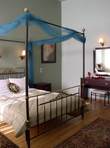 a bedroom with a bed with a blue canopy at Allotino Pension in Nafplio