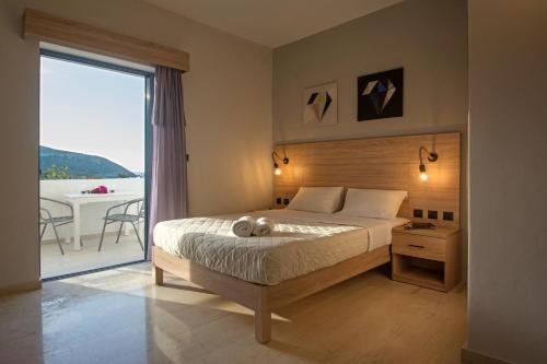 a bedroom with a bed and a large window at Sirene Villas in Diakofti