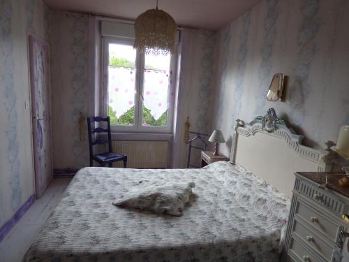 a bedroom with a bed with a towel on it at Beau Site Guimauve et Vieilles Dentelles in Royères-Saint-Léonard