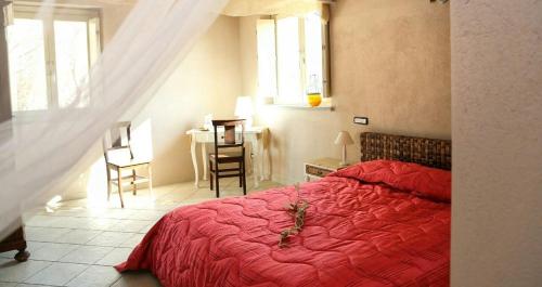 クーネオにあるB&B Casa Marvitaのベッドルーム1室(赤いベッド1台、テーブル、椅子付)