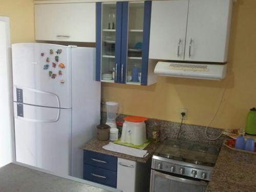 een keuken met witte kasten en een witte koelkast bij Resort Aquaville Apartmento in Aquiraz