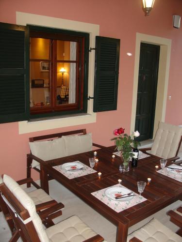 a dining room with a wooden table and white chairs at Villa Magia in Ýpsos