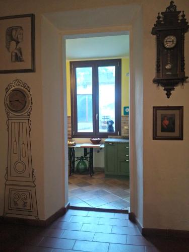 a hallway with a clock on the wall and a window at Zia Chiarina in San Nicolò Gerrei