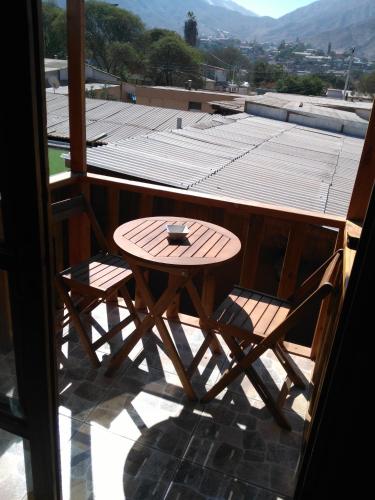 a wooden table and two chairs on a balcony at Hostal Cactus Copiapo in Copiapó