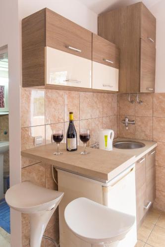a kitchen with two glasses of wine on a counter at Apartments & Studios Tomanović in Budva