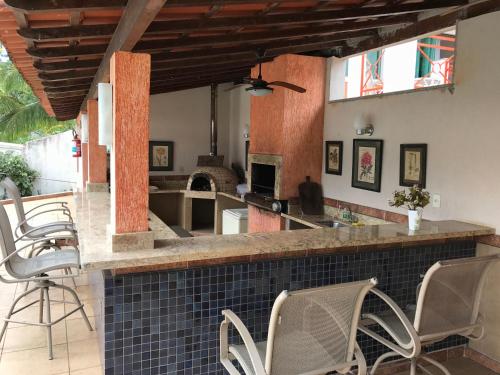 a kitchen and living room with a counter and chairs at Pousada Doce Vida Guarapari in Guarapari