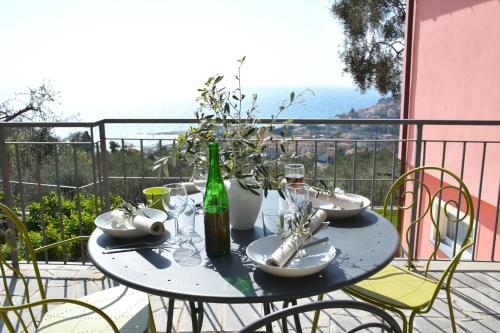 a table with a bottle of wine and glasses on a balcony at La Torretta in Imperia