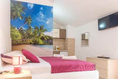 a bedroom with two beds and a painting of a beach at Apartments & Studios Tomanović in Budva