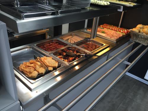 un buffet con diversi vassoi di cibo in una cucina di Pokoje Gościnne Dask Aqua Holiday a Łeba