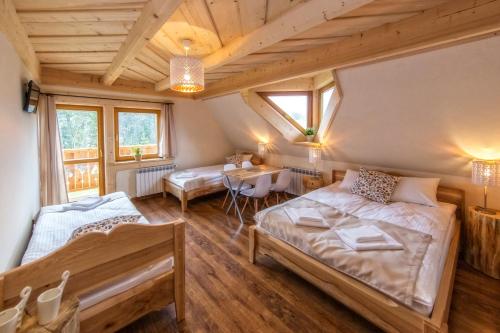 a bedroom with a bed and a table in a room at Willa Giewontka in Witów