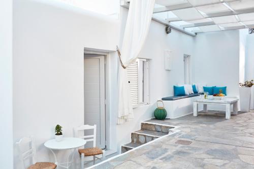 a white living room with a table and chairs at Mykonos Town Suites in Mikonos