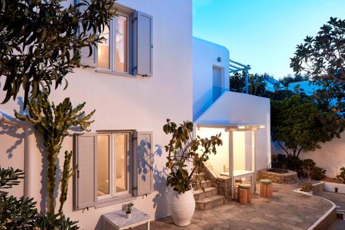 een wit huis met een boom ervoor bij Mykonos Town Suites in Mykonos-stad