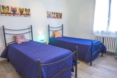 two beds with blue sheets in a room at Casa Marco - Villa alle Cascine - Imperia in Imperia