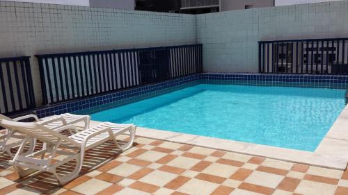 a swimming pool with two chairs and a pair at Studio Everest Flats in Recife