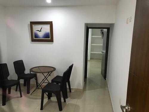 a room with a table and chairs and a picture at Mayva AprtaHotel in Santa Marta