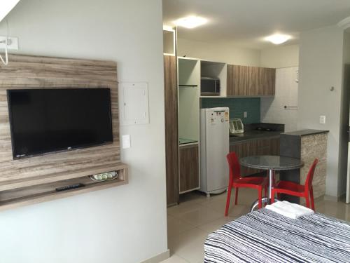 a kitchen with a television and a table and chairs at Studio Everest Flats in Recife