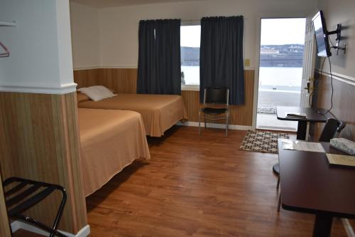 a hotel room with a bed and a desk and window at Gorgeous View Motel in Watkins Glen