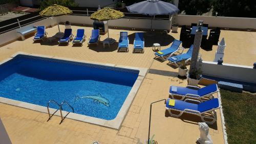 an overhead view of a swimming pool with chairs and a shark in the water at Villa V4 Filomena in Mosqueira