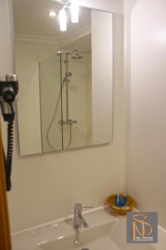a bathroom sink with a mirror and a shower at Rocha Prestige - Guest House and Suites in Portimão