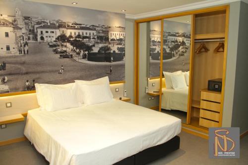 ein Schlafzimmer mit einem Bett und einem Poster einer Stadt in der Unterkunft NDS Prestige Guest House and Suites - by Rocha Prestige in Portimão