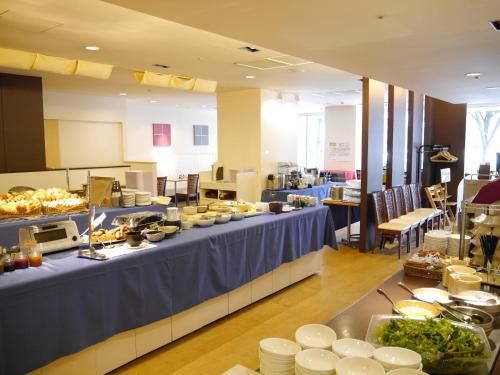 a buffet line with a table with food on it at HOTEL MYSTAYS Nagoya Sakae in Nagoya