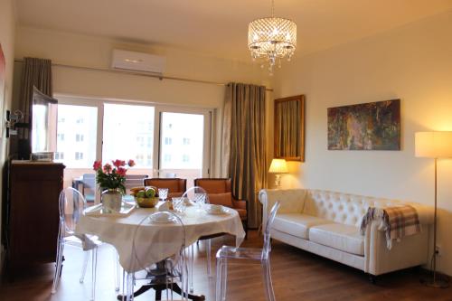 Una sala de estar con un sofá, una mesa y sillas. en QUAD 2, en Lisboa