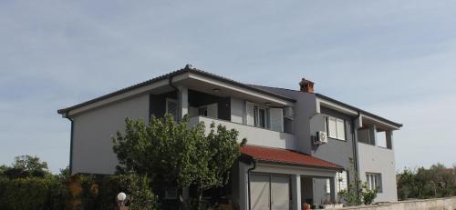 a large white house with a red roof at Holiday House Zaton in Zaton