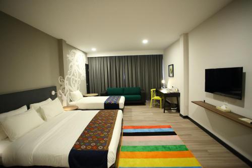 a living room filled with furniture and a bed at @Thome Boutique Hotel in Bintulu