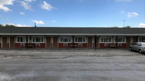 a red building with a car parked in front of it at Budget Inn in Sedalia