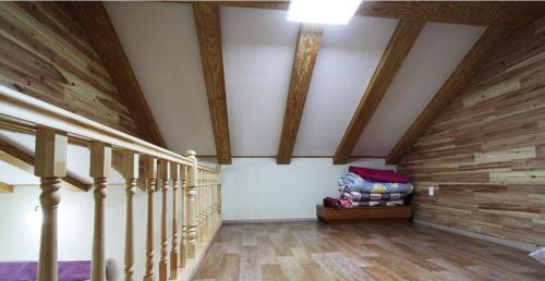 a room with a staircase with wooden floors and wooden ceilings at Gyeongju Family Pension in Gyeongju