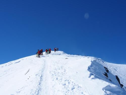 a group of people standing on top of a snow covered mountain at Nori's Sharehouse Hakuba in Hakuba